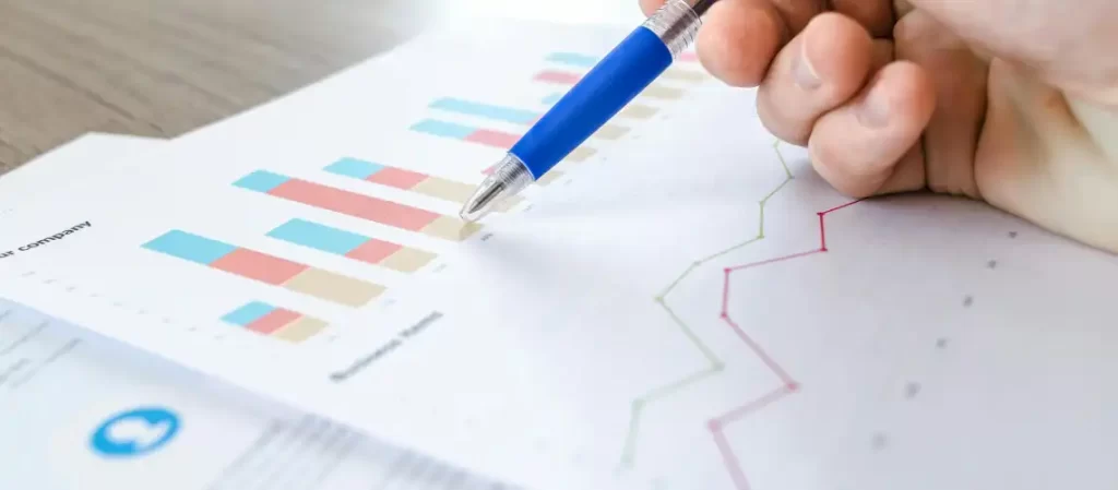 Professional reviewing commercial property data on a laptop with charts and graphs